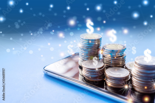 make money online,  business e- commerce concept with stack of coin on mobile phone with technology background photo