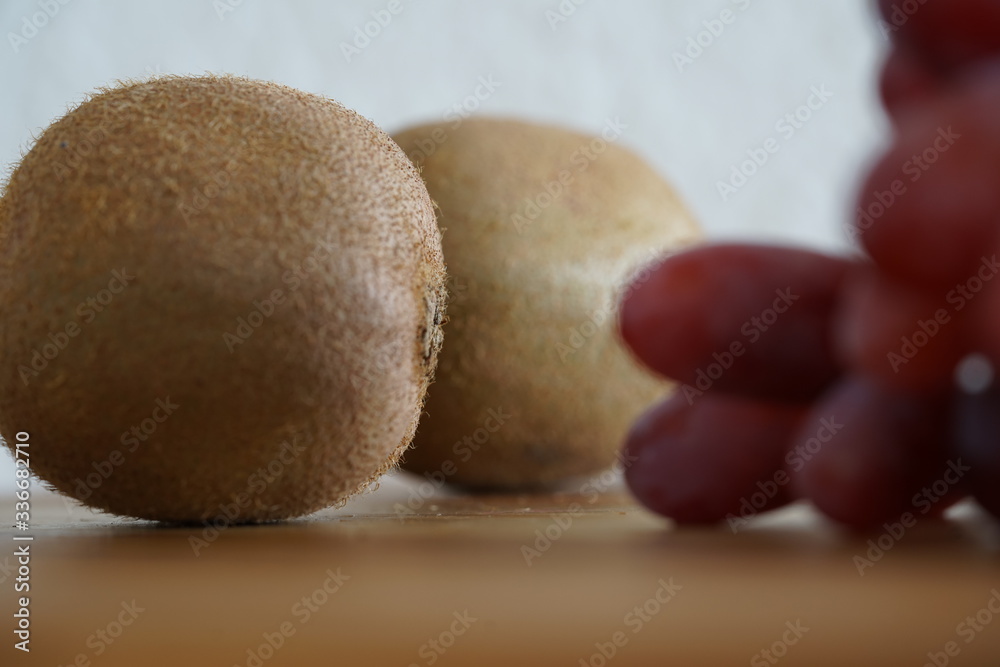 Kiwi und rote Weintrauben auf einem Küchenbrett Kiwi und rote Weintrauben auf einem Küchenbrett