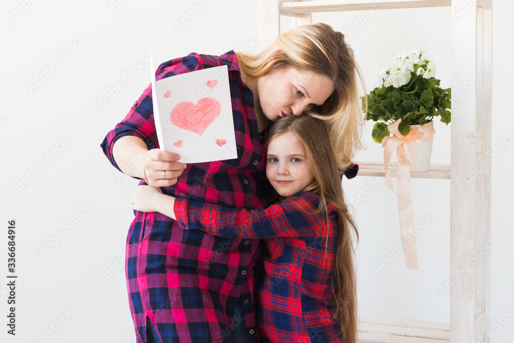 Mother's Day and family holidays - Mother reading greeting card from her daughter. Mother's Day and family holidays - Mother reading greeting card from her daughter.