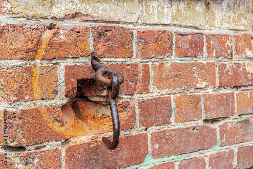 Rusty iron hook in the brickwork of an old gate