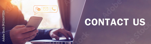 Close up businessman using laptop holding mobile smart phone, using device to contact people or contacting information on business, concept of contact us messaging calling email, with graphic icon