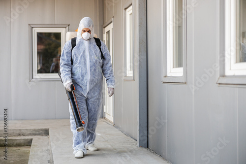 Cleaning and Disinfection outside around buildings, the coronavirus epidemic. Professional teams for disinfection efforts. Infection prevention and control of epidemic. Protective suit and mask.