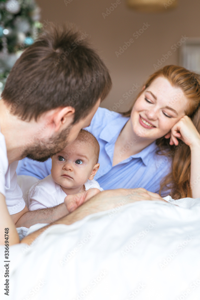 Three-month-old baby in the arms of happy young parents. The most touching moments with father and mother