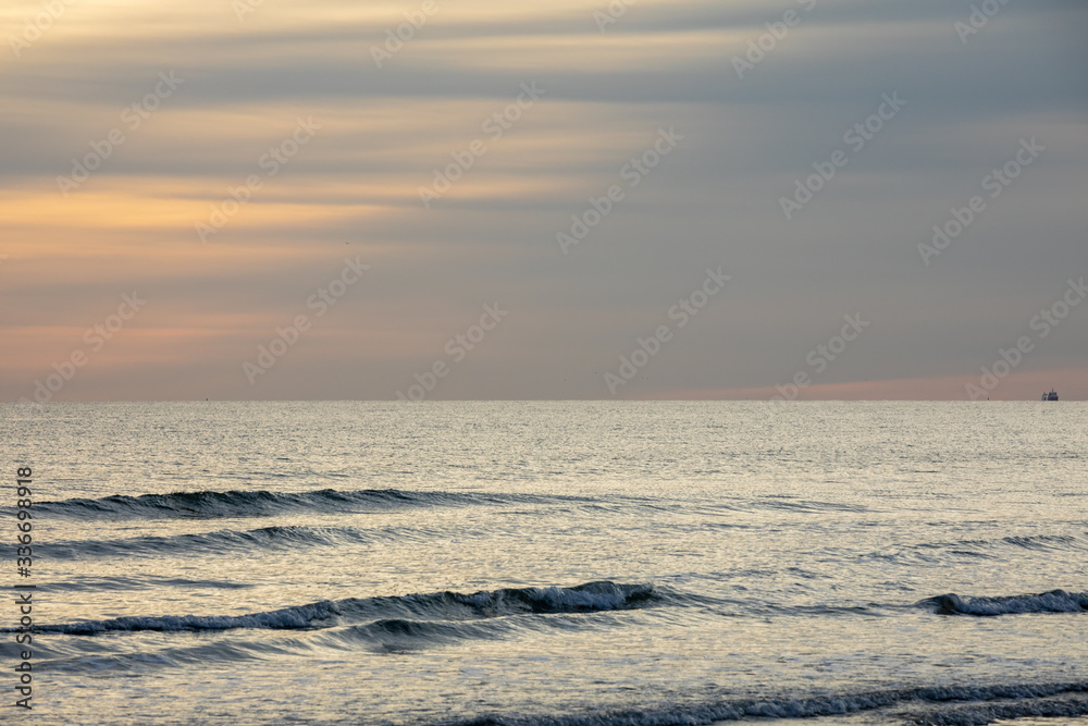 Fototapeta premium Seascape at sunset with muted colours over a tranquil sea on the south coast of England.