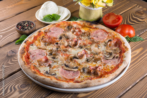 Delicious pizza with cheese, tomatoes, olives and greens