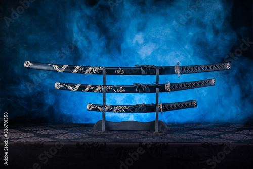 Three swords on stand, blue smoke behind