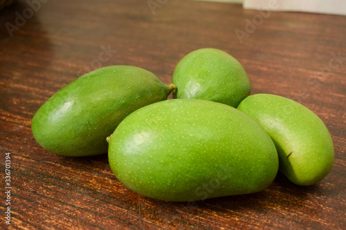 Organic Young Green Mangoes on Wooden Table sour fruits.