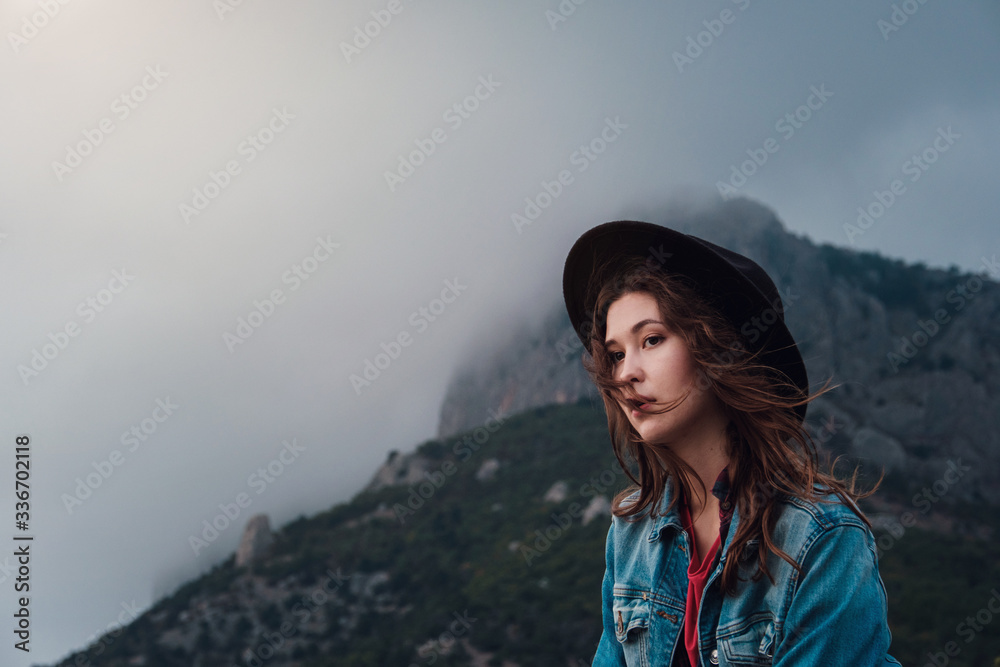 happy traveler hipster girl on top of cloudy mountains.