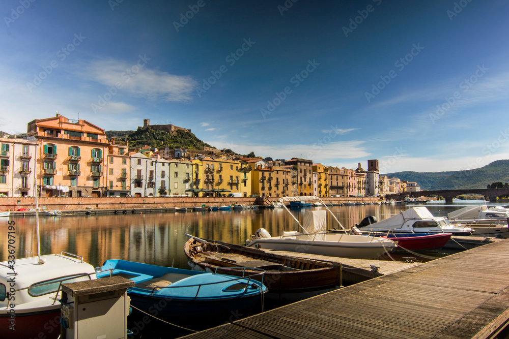 Temo river in Bosa, a town in Sardegna Italy, with houses reflection, boats and a castle in the background