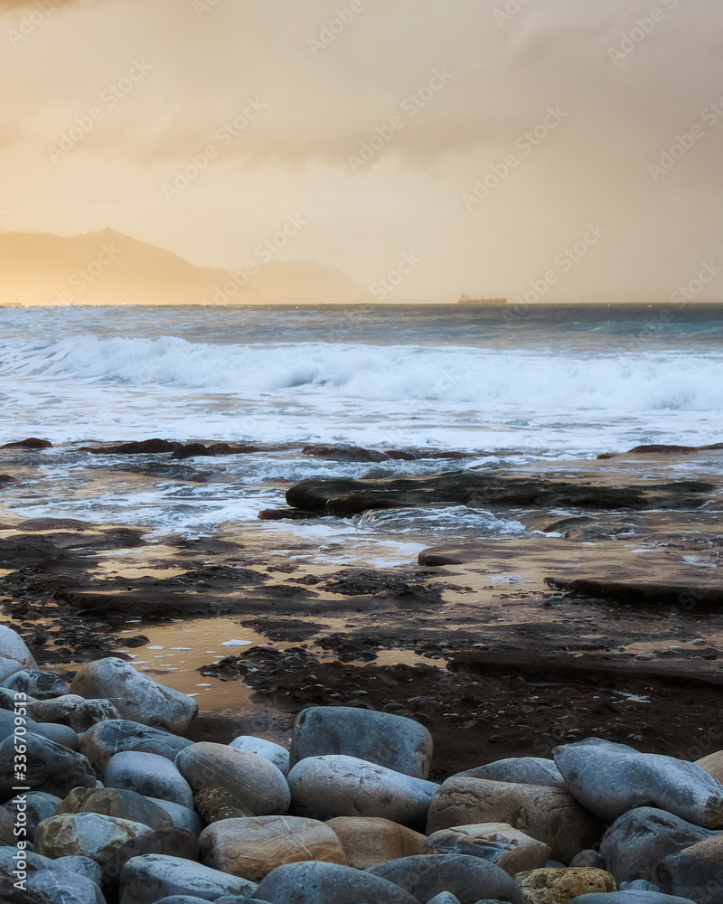 Azkorri (Getxo Basque Country) beach at sunset Orange sunset with rocks waves and sea Azkorri (Getxo Basque Country) beach at sunset Orange sunset with rocks waves and sea