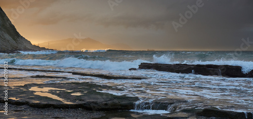 Azkorri (Getxo Basque Country) beach at sunset Orange sunset with rocks and waves