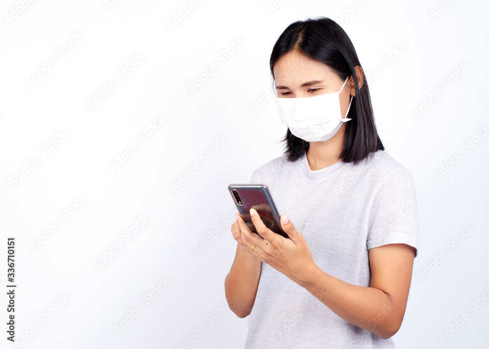 Asian woman portrait wearing mask for protect Covid 19 or coronavirus with using smartphone on white backgrounds for social distancing Asian woman portrait wearing mask for protect Covid 19 or coronavirus with using smartphone on white backgrounds for social distancing