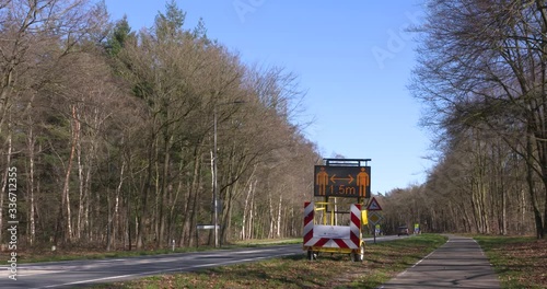 VELUWE, THE NETHERLANDS - MARCH 2020: Trailer-mounted VMS variable-message sign (Portable Changeable Message Signs or PCMS) warning the public to keep distance during the coronavirus pandemic.