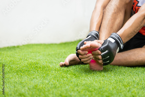 Close up on foot sole Injury. The man use hands hold on his foot sole while running in the park. space for text or design. highlight on injured area