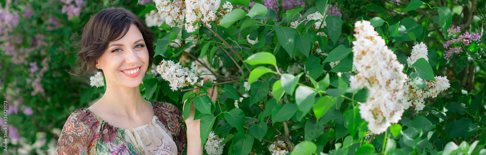 Closeup portrait of beautiful woman enjoying the smell of Lilac. Young girl in spring landscape background. Cover face healthy skin. Beauty clinic skincare organic natural spring concept banner Closeup portrait of beautiful woman enjoying the smell of Lilac. Young girl in spring landscape background. Cover face healthy skin. Beauty clinic skincare organic natural spring concept banner