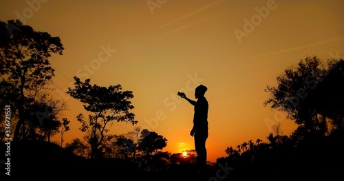 A young man takes a selfie at sunset