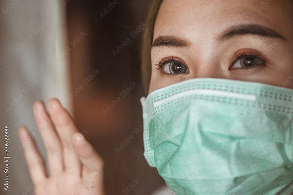 Woman wearing mask protection at the window wait for epidemic situation to improve soon at home. Coronavirus, covid-19, Work from home (WFH), Social distancing, Quarantine, Prevent infection concept. Woman wearing mask protection at the window wait for epidemic situation to improve soon at home. Coronavirus, covid-19, Work from home (WFH), Social distancing, Quarantine, Prevent infection concept.