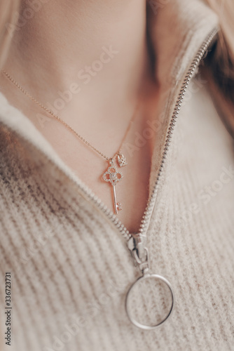 Woman wearing elegant key pendant necklace on close-up photo