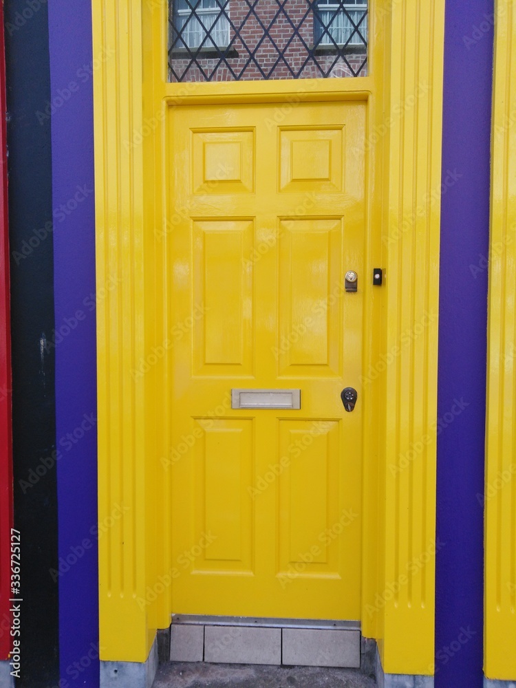 bright sunshine yellow door with navy blue painted walls