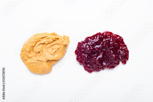 Bilde på lerret Peanut butter and lingonberry jam over white background, top view
