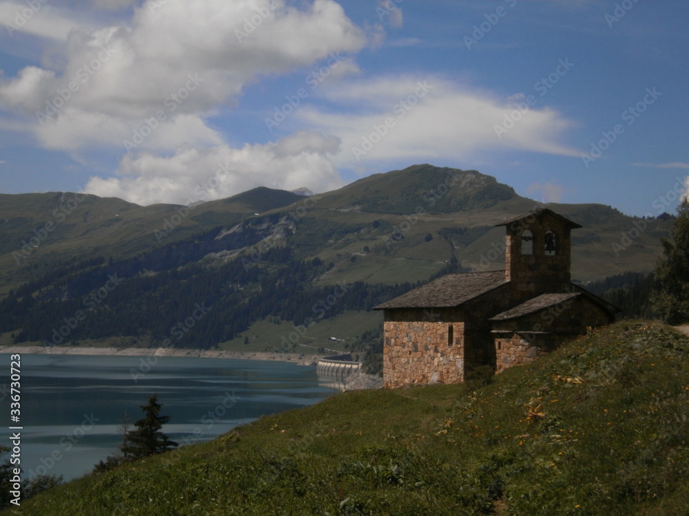 View of a small chapel and the lake Roselend, which is mainly a reservoir in the French alpine mountains.