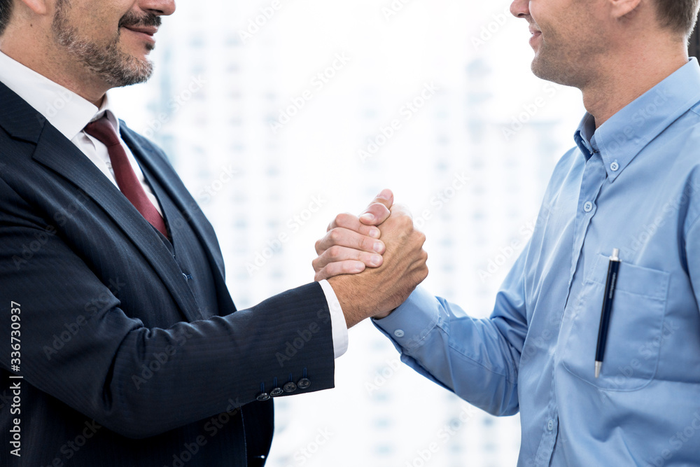 Business people shake hands when reaching a business agreement together.