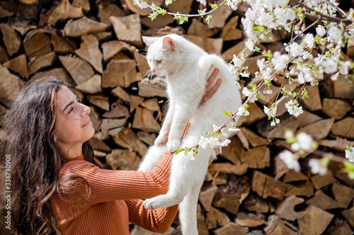Adorable baby strolling and playing with a pet white cat