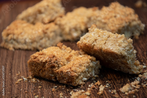 Closeup of home-baked oat crunchies, on wooden board, kitchen baking