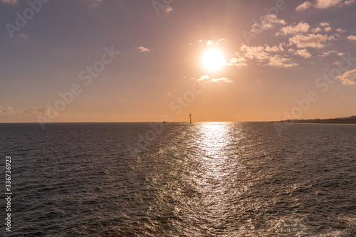 Sunrise from a cliff with moving clouds in a different direction forming a line where the sun rises on the sea and forms rays reflecting on the ocean surface from the Grand Canary.