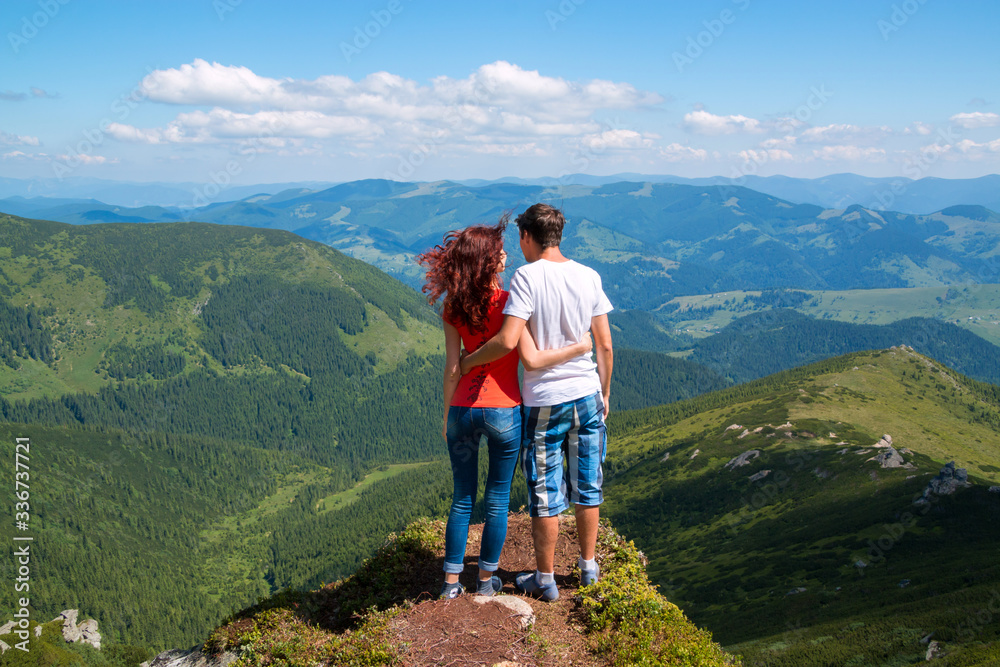 Happy couple hugging in the top of mountain.