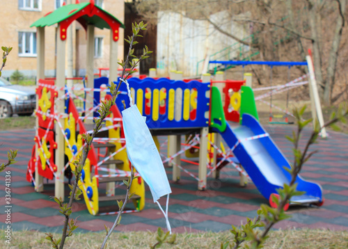 Mask on the background of a closed kids playground during the quarantine coronavirus, no kids, epidemic Covid 19 pandemic, sars-cov-2, coronavirus