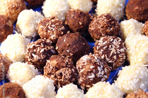 Handmade round brown and white candies with cocoa and coconut