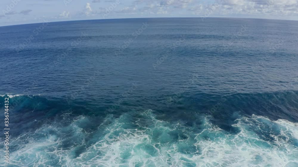 Aerial view of blue ocean with beautiful foaming rolling waves at sunny day Aerial view of blue ocean with beautiful foaming rolling waves at sunny day