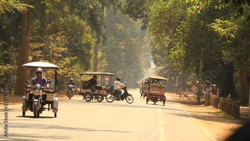 Photography Tuk tuts driving down road in Cambodia