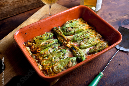 Stuffed zucchini flowers in baking dish