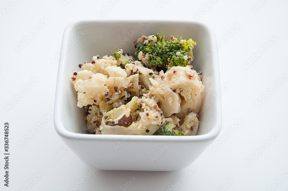 Vegan casserole food with broccoli, cauliflower, beans and quinoa served in a square bowl on a light background. Great for healthy lifestyles and whole plant diets with this vegetable side dish. Vegan casserole food with broccoli, cauliflower, beans and quinoa served in a square bowl on a light background. Great for healthy lifestyles and whole plant diets with this vegetable side dish.