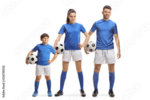 Young man, woman and a boy in sports jersey holding soccer balls