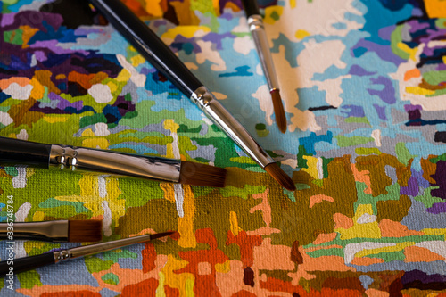 Art brushes and painting. Brush strokes of bright colors close-up. A fragment of the picture. Macro photo. Painter
