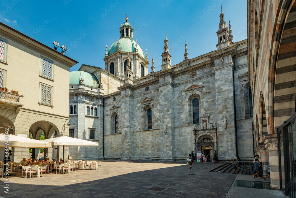 Como, ITALY - August 4, 2019: Local people and tourists on a quiet cozy streets near Cathedral in the beautiful Italian Como city. Warm sunny summer day in very popular holiday destination