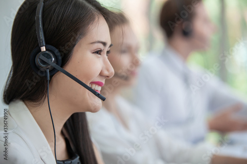 operator woman agent with headsets working in a call centre. woman asian Smiling customer support operator at working