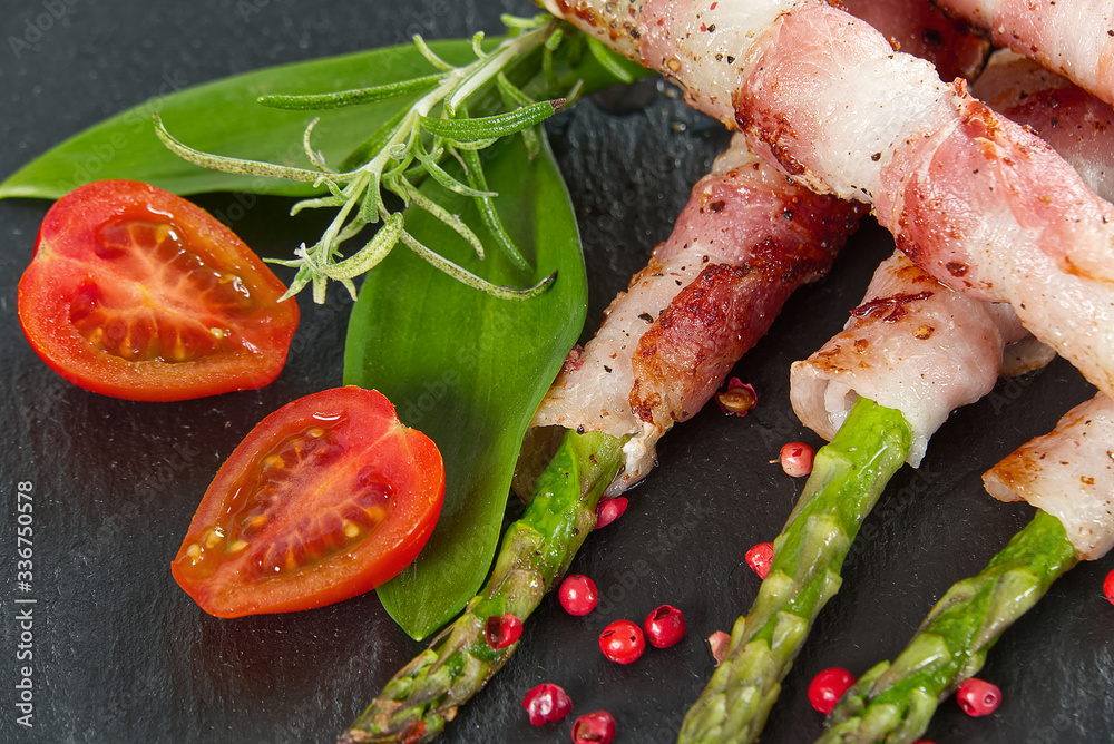 Asparagus with bacon served on black stone. healthy food - breakfast. dark food background.