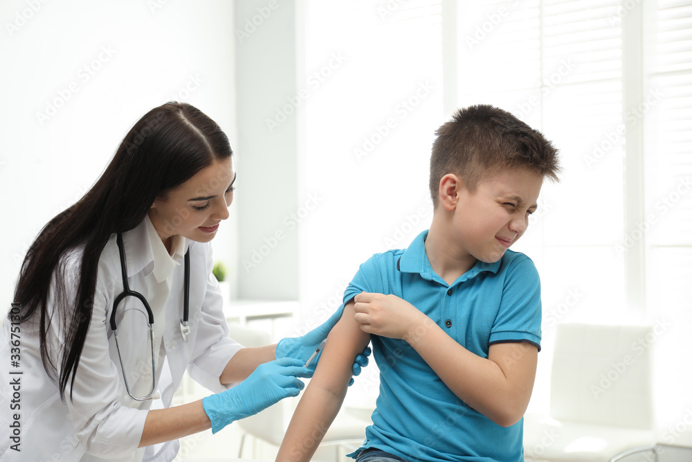 Doctor vaccinating little child in modern clinic Doctor vaccinating little child in modern clinic