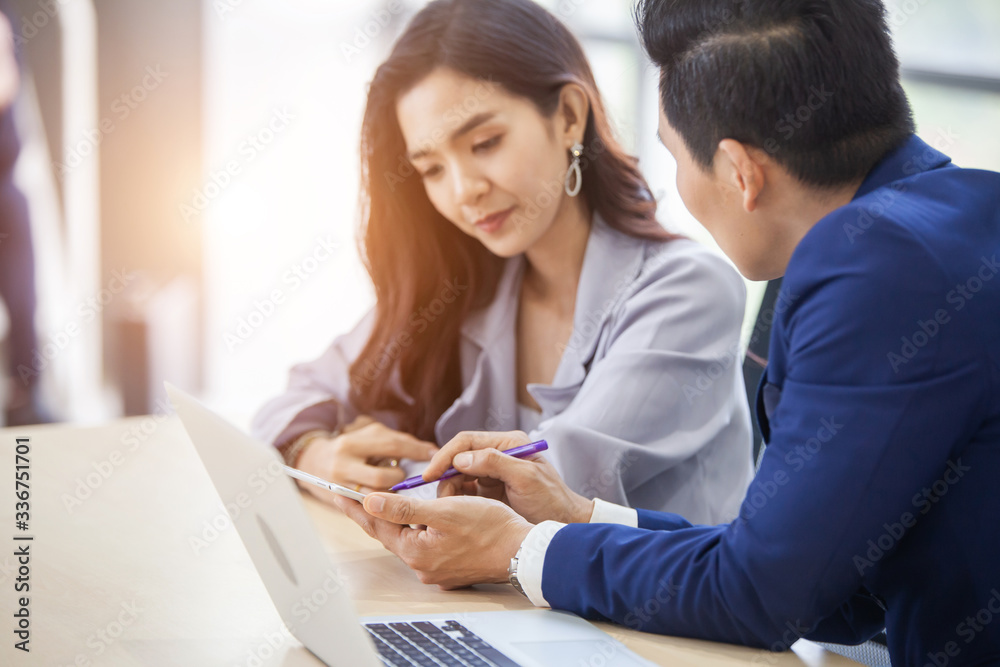 two young asian businessmen using touchpad at meeting two young asian businessmen using touchpad at meeting