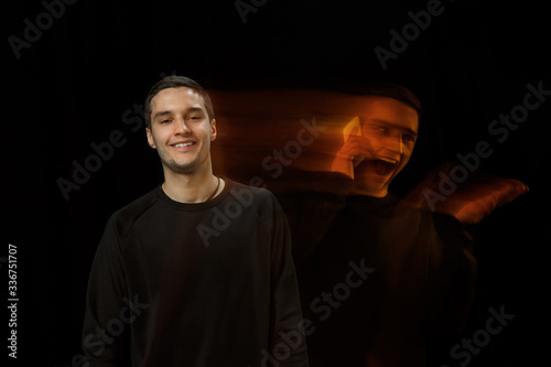 Smiles outside, laughting inside. The versatility of man - opened emotions and hidden feelings. Caucasian man on black background with different faces of condition. Double exposure. Mental health.