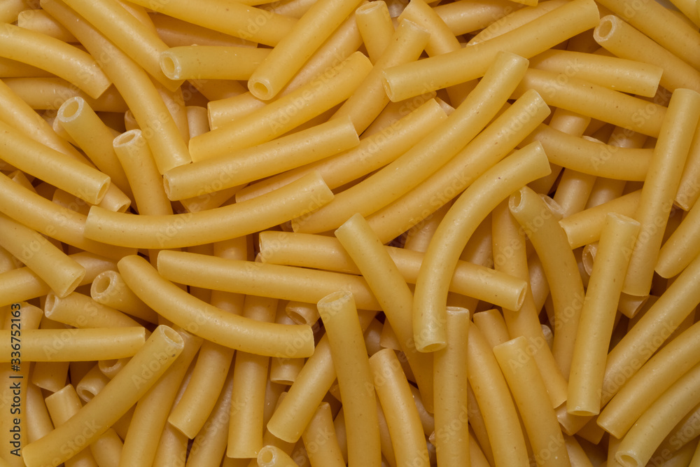 Uncooked smooth short tubes shape pasta also known as tubetti lisci background and texture Uncooked smooth short tubes shape pasta also known as tubetti lisci background and texture