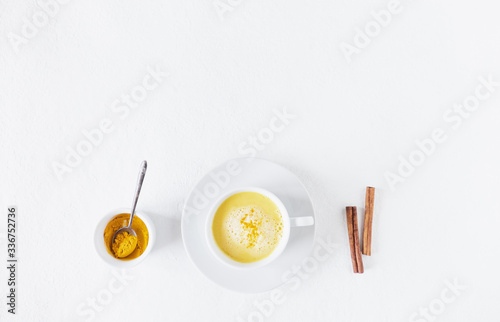 Traditional indian drink turmeric golden milk in a cup with ingredients, curcuma, honey, star anise