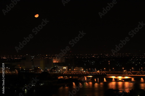 Bangkok city on a night in curfew, lockdown the epidemic of Covid-19 and the moon orbits the nearest world of the year