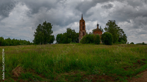 A cloudy landscape with an abandoned Church standing among trees. Ivanovo region, Russia.