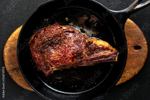 Overhead view of rib eye steak on skillet photo