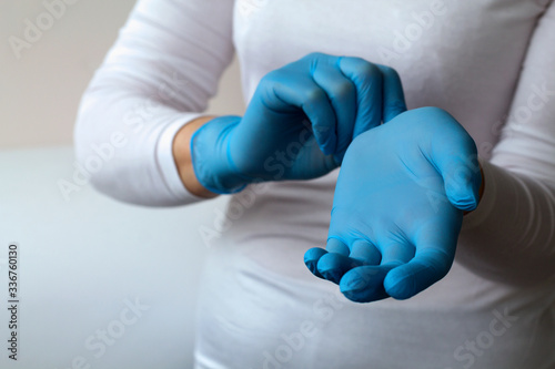 woman puts on protective blue gloves. Medical healthcare. Doctor hands in gloves in hospital. Professional medicine health clinic practitioner. People in white uniform in lab. copy space